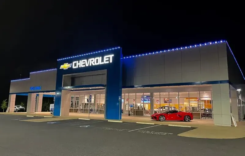 Blue and white roofline lighting on a Chevrolet dealership at night