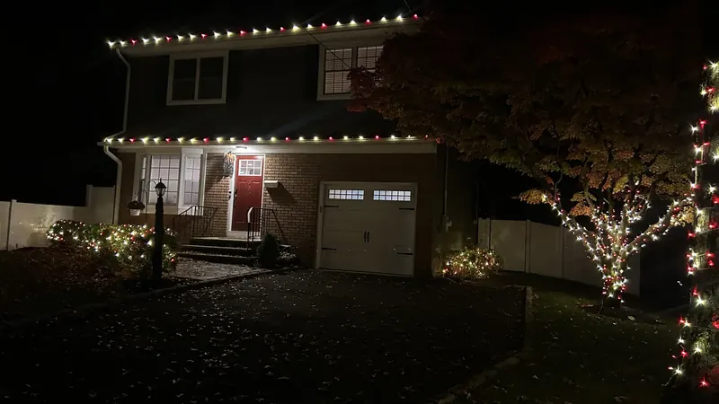 Kasa Christmas lighting on a home, with roofline lights and a wrapped tree